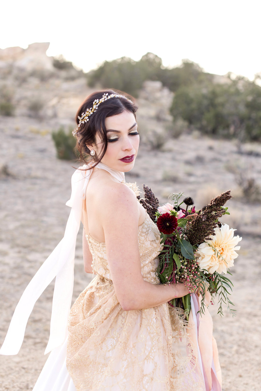 wedding planning photography styled shoot natural light outdoor elopement engagement New Mexico Albuquerque mountains Perfect Wedding Guide headpiece makeup hair updo smoky eye gold neutral bouquet lace high neck greenery bold lip gold details dress