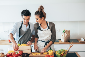 Engaged couple cooks together in the kitchen.