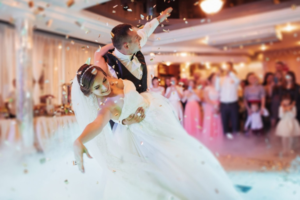 Newly married couple performs a choreographed dance at their wedding reception.