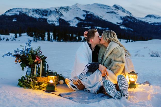 Colorado elopement packages. A Colorado couple elopes during the winter and sits outside on a blanket at dusk.